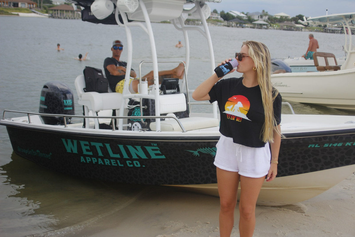 Black Get Em Wet sunset crop top worn by a woman at the dock